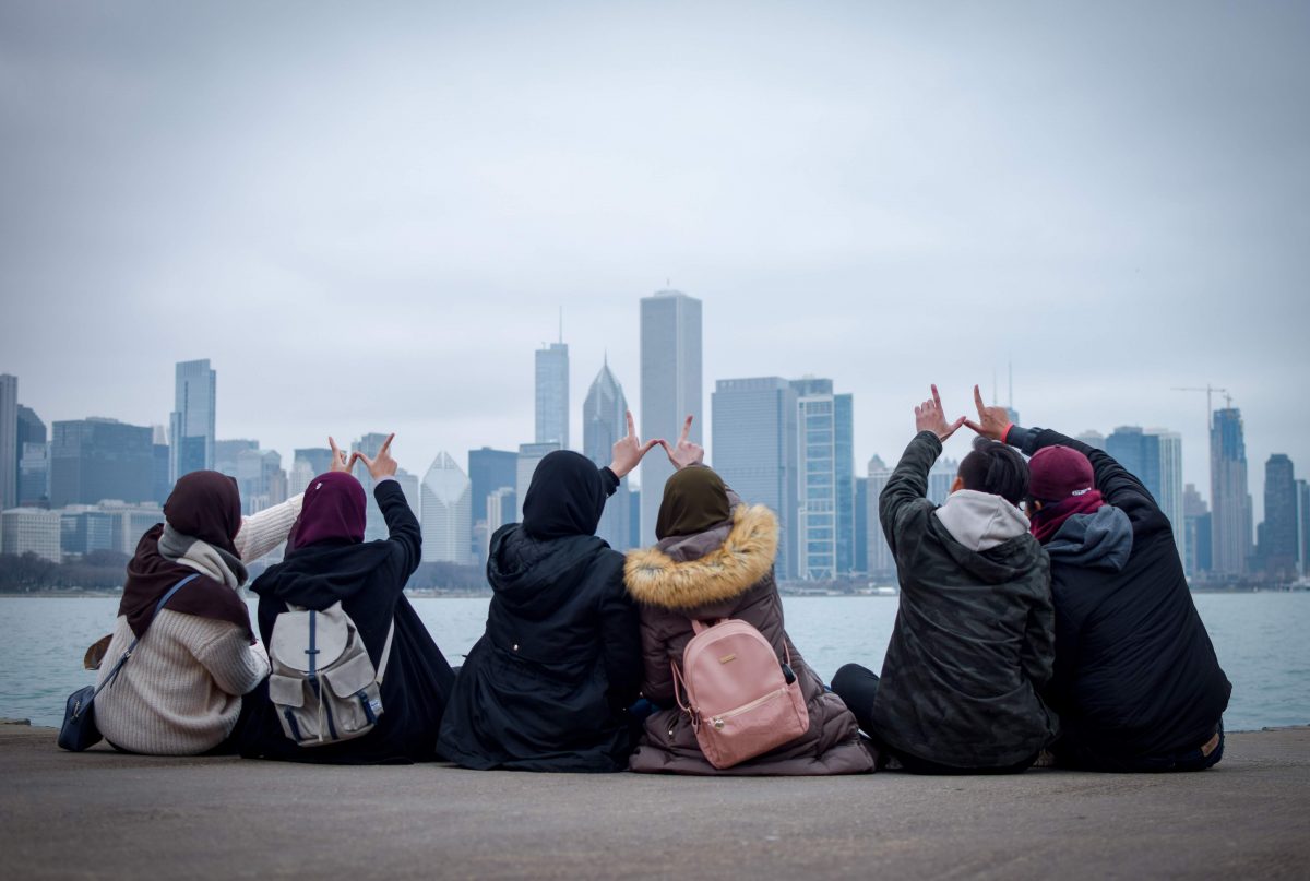students holding up there hands in a 'W'