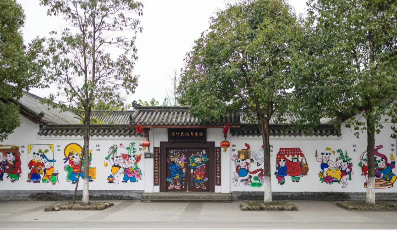 Exterior view of the entrance to the Mianzhu Nianhua Museum workshop studio. Two large door deities are permanently painted onto the double leaf door, with traditional Nianhua figures painted onto the wall.