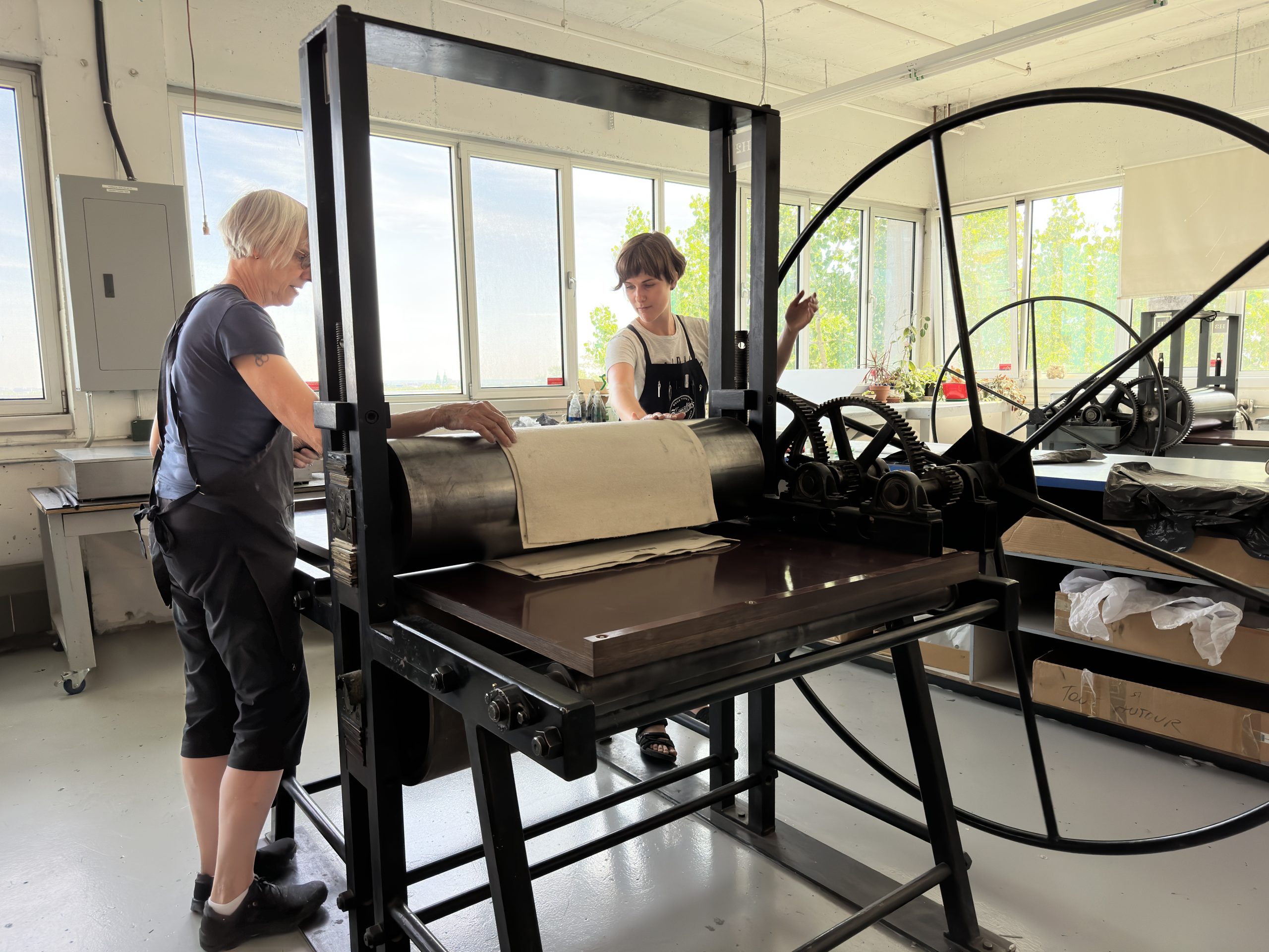Two women working at printmaking at the Atelier Circulaire in Montreal, Quebec.